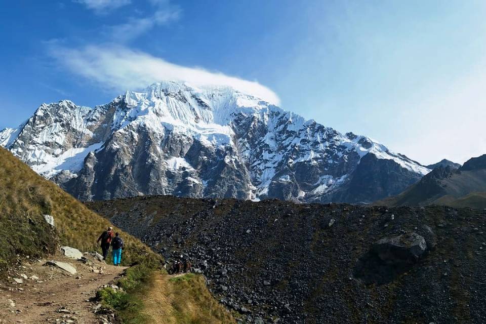 Sendero andino entre montañas nevadas | Trekero