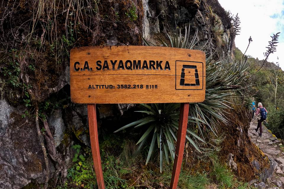 Letrero de Sayacmarca junto al sendero de piedra del Camino Inca