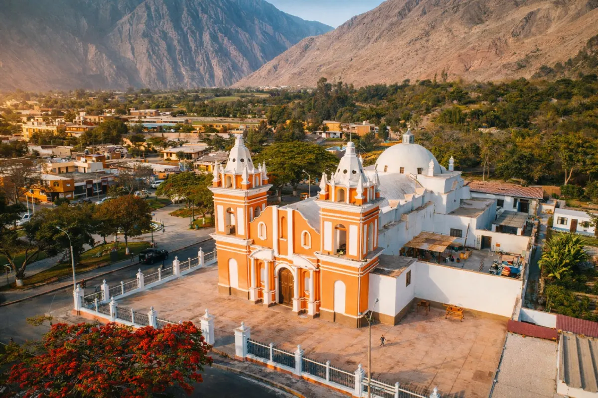 Vista aérea de la iglesia principal de Lunahuaná rodeada por el valle, árboles y montañas en la provincia de Cañete.