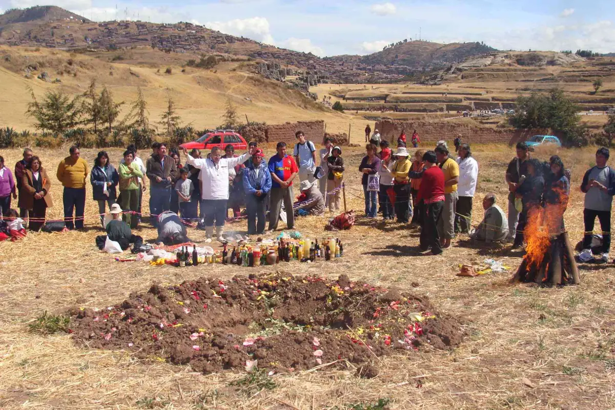 Pago a la Tierra en Sacsayhuamán con ofrendas a la Pachamama y participantes reunidos en una zona andina