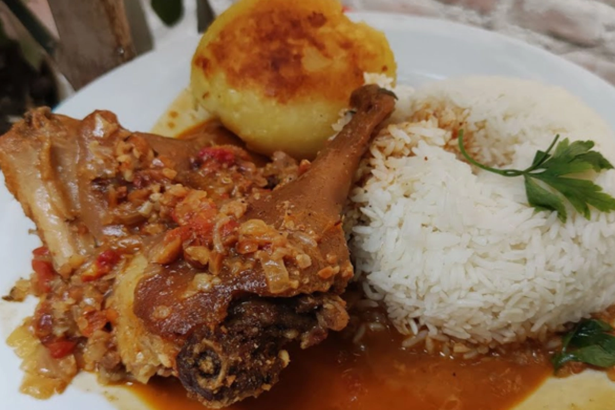 Pepián de cuy servido con arroz blanco, papa dorada y salsa