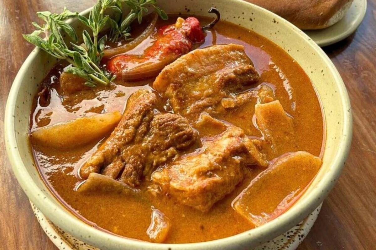 Adobo de cerdo en caldo rojizo con ají panca y especias