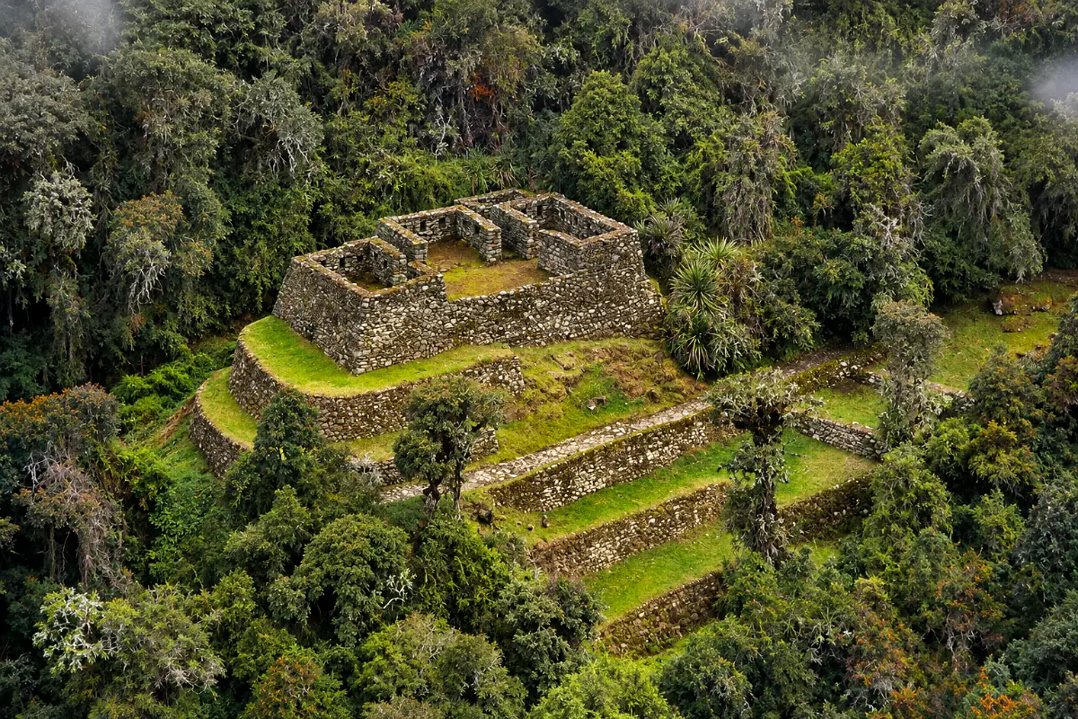 Vista aérea de Conchamarca con recintos rectangulares de piedra y terrazas rodeadas de bosque nuboso