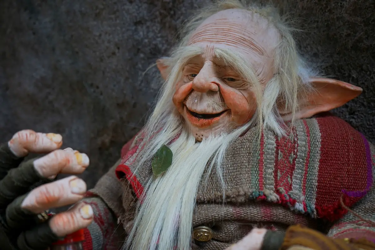 Primer plano de un duende sonriente con cabello blanco y orejas puntiagudas