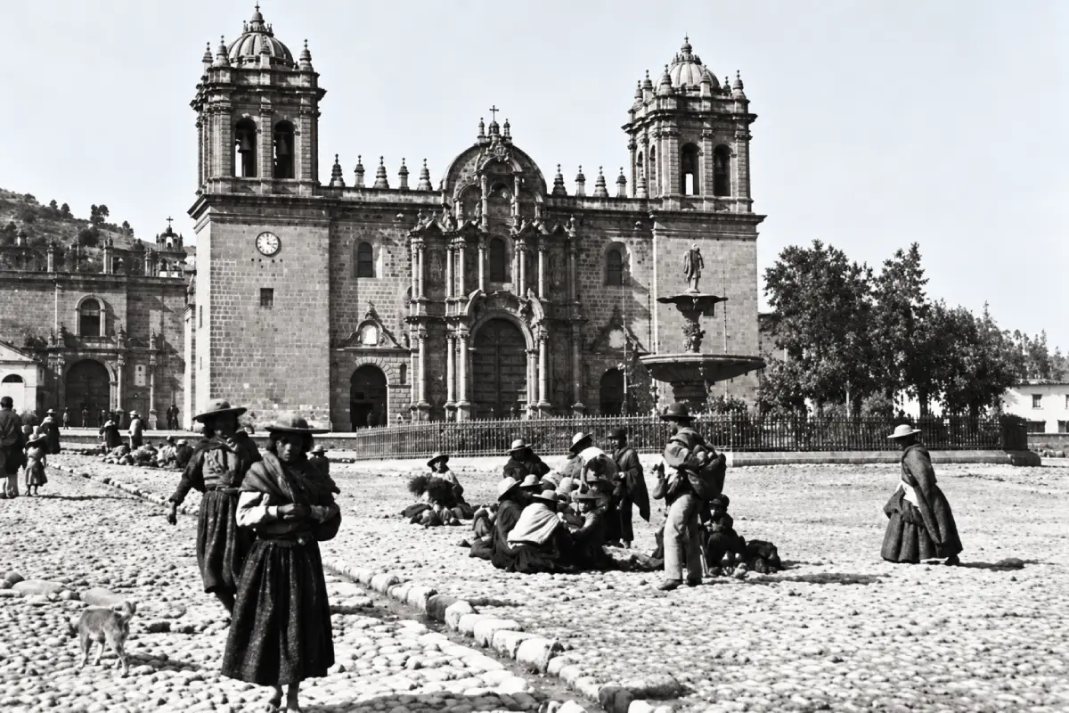 Fotografía histórica en blanco y negro de la Catedral del Cusco, con habitantes vestidos a la antigua y una plaza empedrada