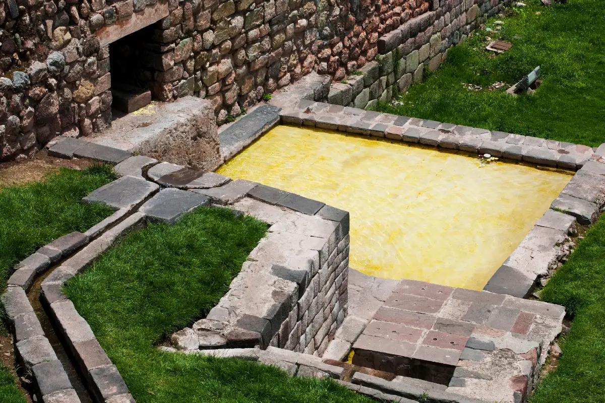 Estanque rectangular de piedra conectado a un canal de agua en los jardines del Coricancha