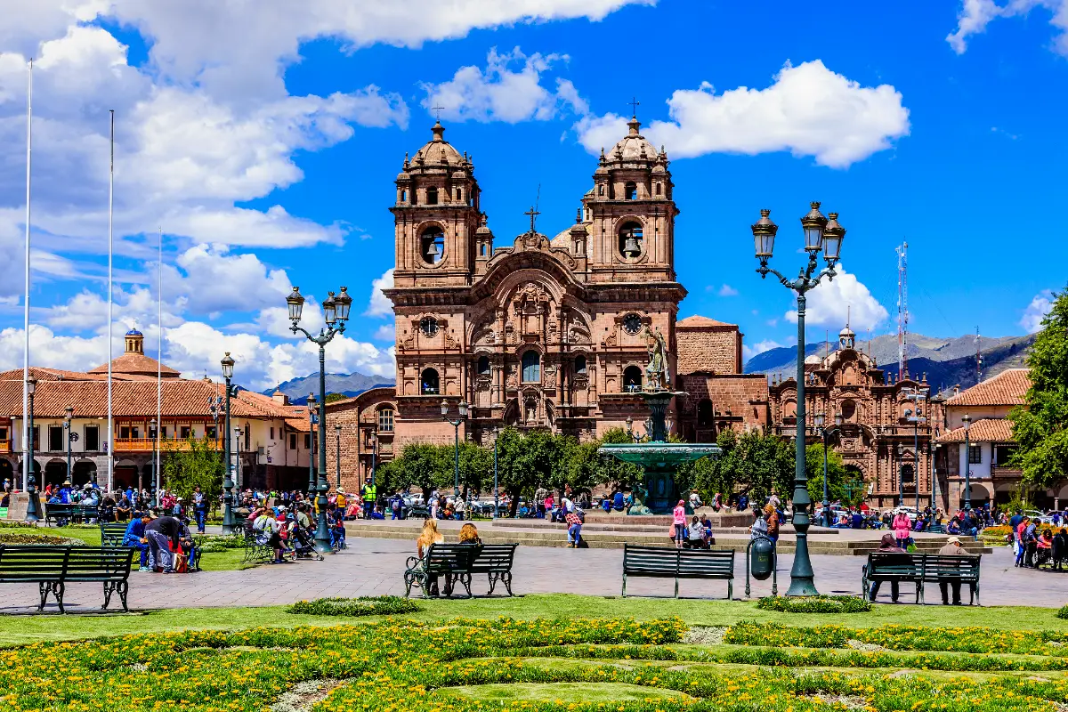  Iglesia de la Compañía de Jesús del Cusco, con dos torres campanario, fachada barroca, fuente central y jardines de la Plaza de Armas