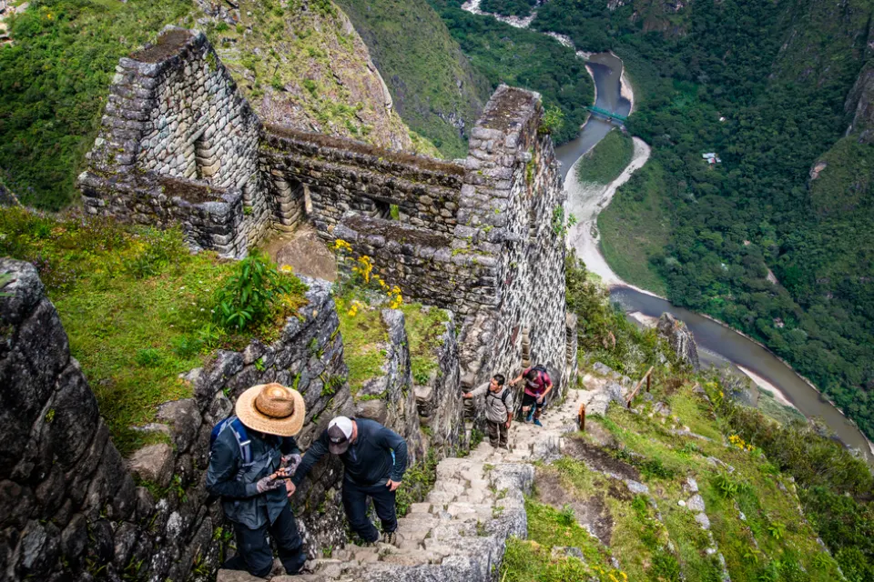 Turistas subiendo por las empinadas escaleras de la Montaña Huayna Picchu - montaña machu picchu vs huayna picchu