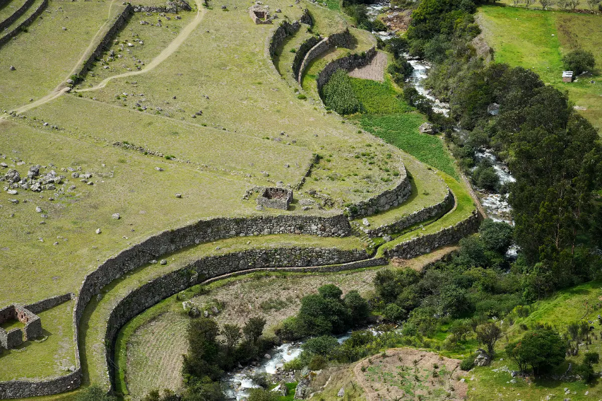 Muros de piedra curvos de Patallacta junto al río Cusichaca y áreas de vegetación