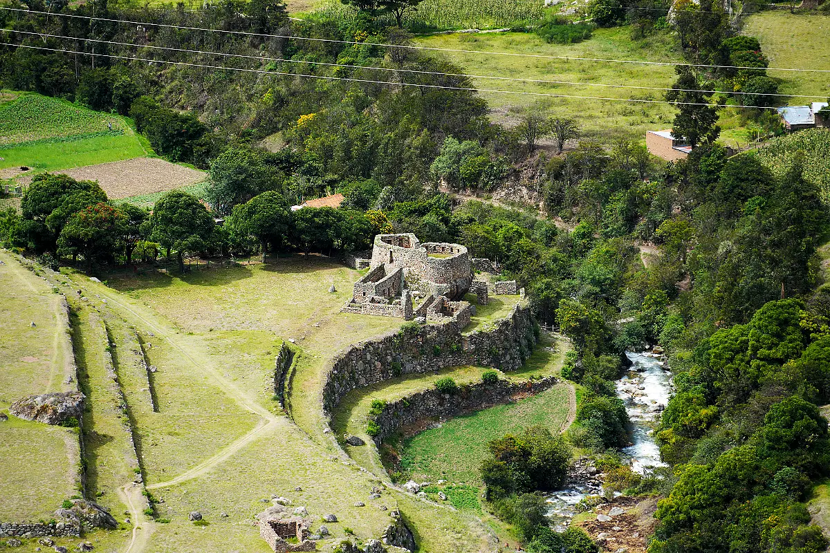 Centro ceremonial de Pulpituyoc con muros curvos de piedra junto al río Cusichaca en Patallacta