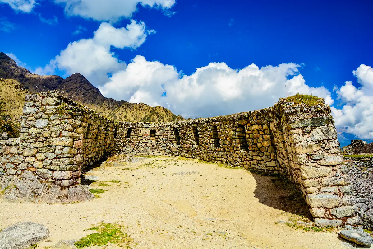 Interior de un recinto semicircular inca con muros de piedra y pequeñas aberturas