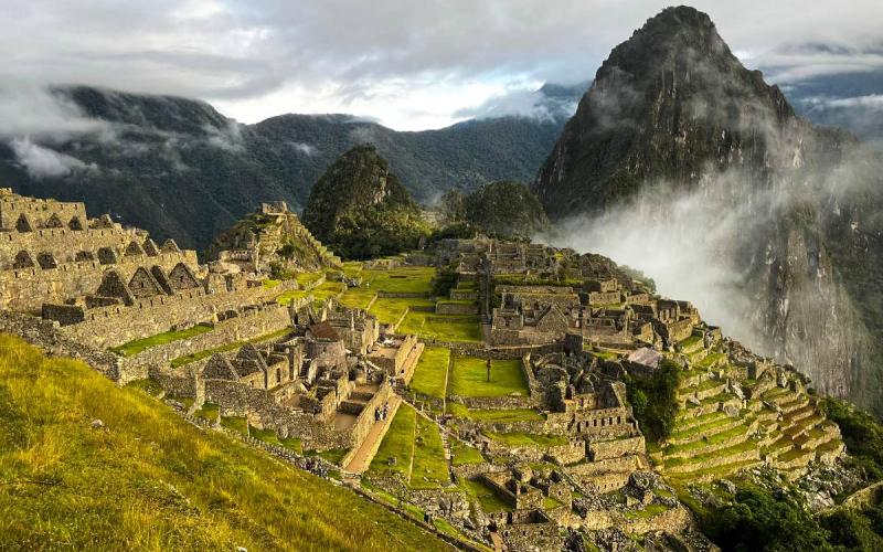 Machu Picchu entre montañas cubiertas por la neblina andina | Trekero