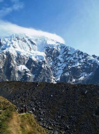 Sendero andino entre montañas nevadas | Trekero