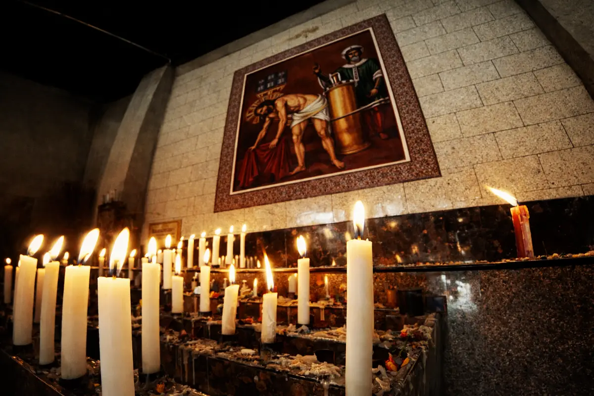 Velas encendidas frente a una imagen del Señor de Huanca dentro del santuario | Trekero